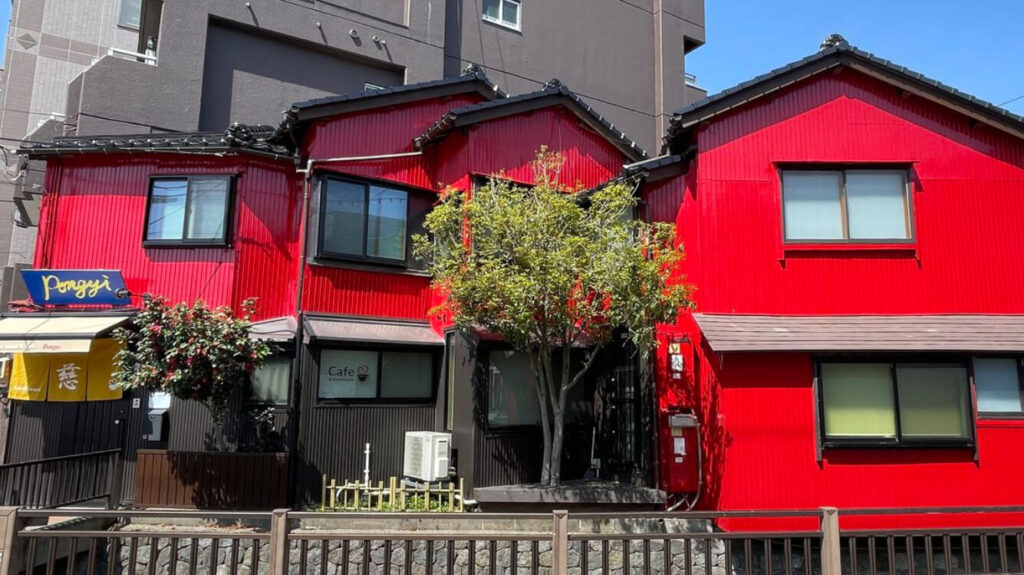 Wide view of Guesthouse Pongyi, a traditional red townhouse guesthouse near Kanazawa Station.