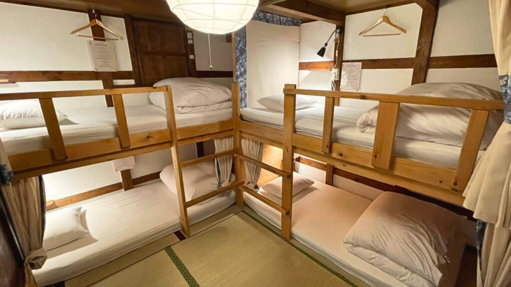 Wide view of the mixed dormitory with tatami flooring and wooden textures at Guesthouse Pongyi.