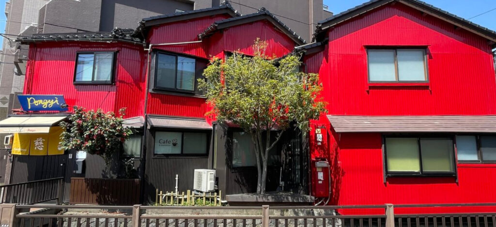 金沢駅近くの古民家ゲストハウス ポンギーの外観。旅人を迎える赤い町家。 | Kanazawa Guesthouse Pongyi exterior – red townhouse near Kanazawa Station.