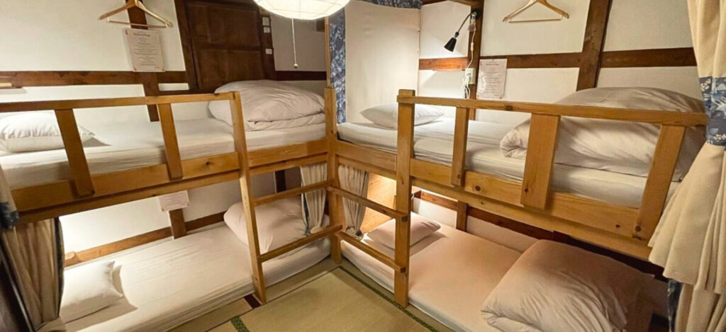 畳と木の香りが広がる男女共用ドミトリー。静かに休める落ち着いた空間。 | Mixed dormitory room at Kanazawa Guesthouse Pongyi with the scent of tatami and wood, offering a calm and relaxing stay